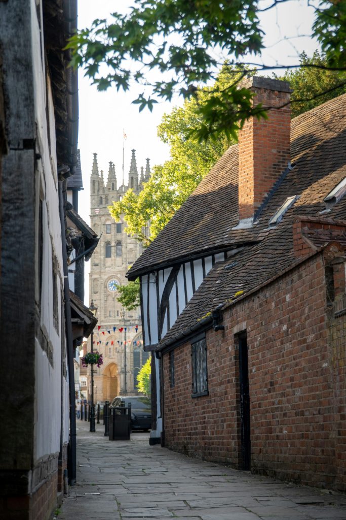 A narrow street leads to a distant church.