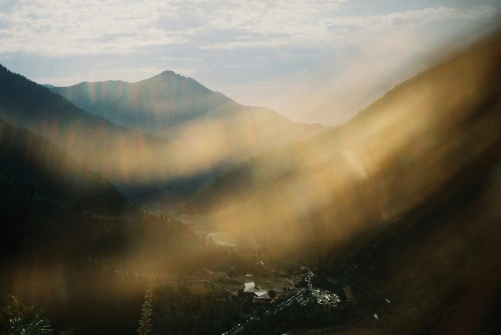 Sunbeams illuminate a valley between mountains