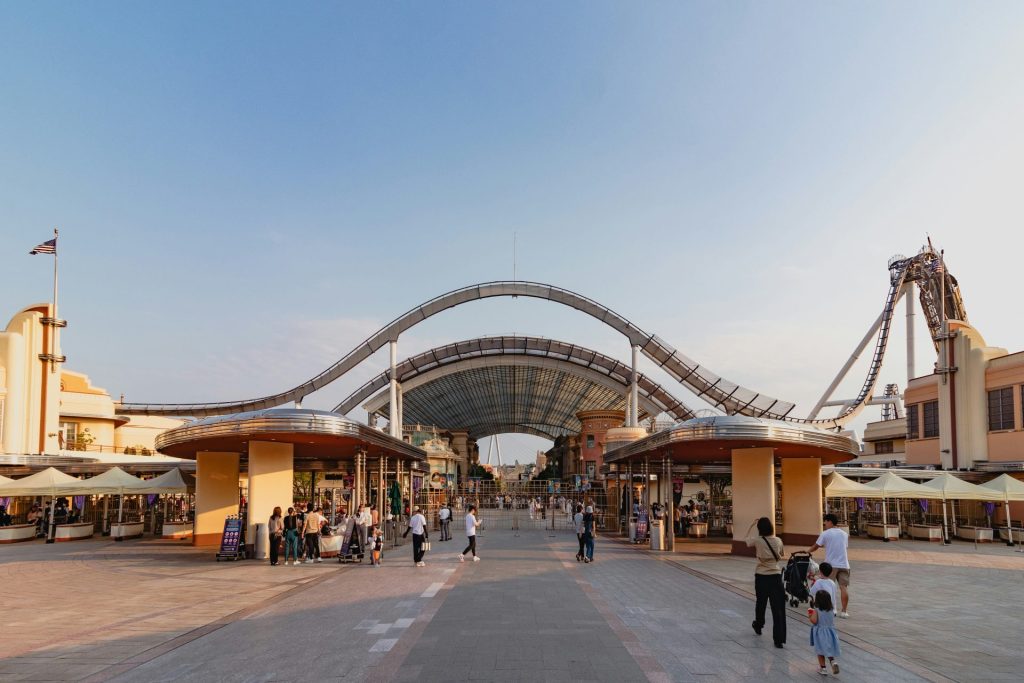 A group of people walking down a street next to a tall building