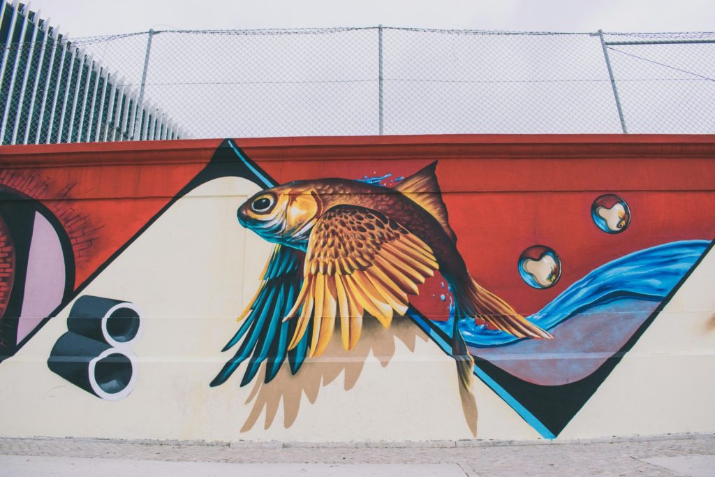Vibrant fish mural capturing creativity and street art on an urban wall.